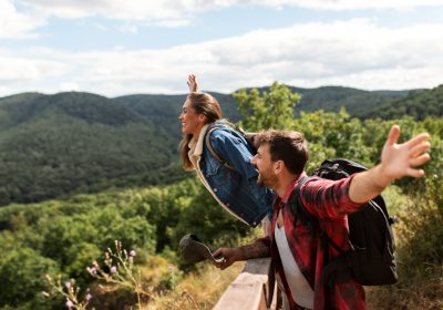 Imagem ilustrativa sobre turismo de aventura mostrando dois turistas no alto de uma montanha após contar com o auxílio da Singular Mobilidade Internacional em seu planejamento.