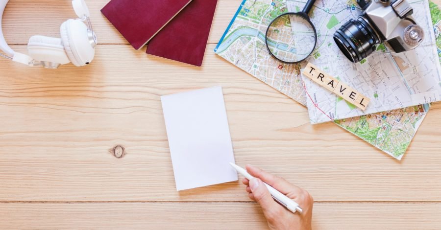 Imagem ilustrativa sobre os vistos de turismo e suas curiosidades mostrando itens de viagem sobre uma mesa.