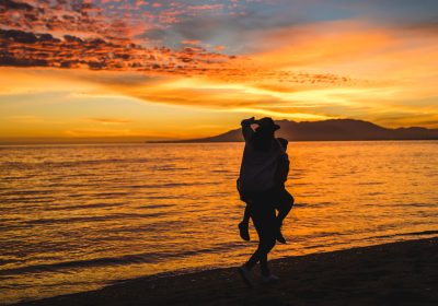 Imagem mostrando um casal em sua viagem de lua de mel em uma praia após contar com o auxílio da Singular Mobilidade Internacional nos preparativos da viagem.