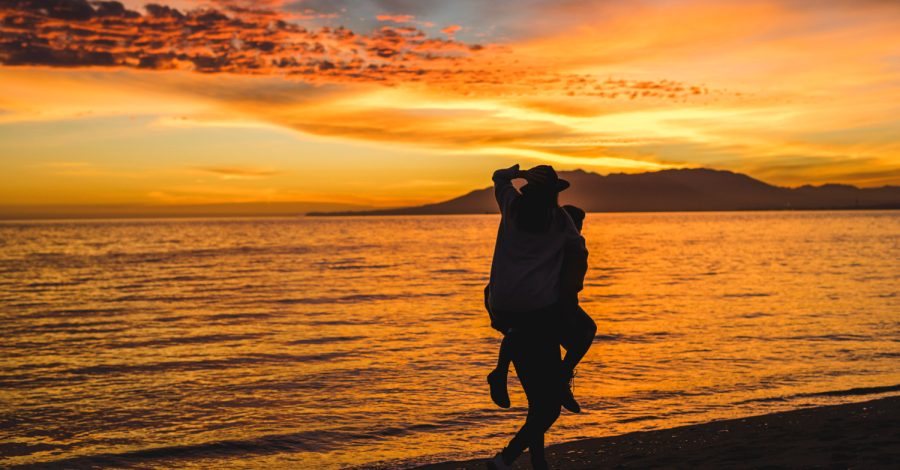 Imagem mostrando um casal em sua viagem de lua de mel em uma praia após contar com o auxílio da Singular Mobilidade Internacional nos preparativos da viagem.