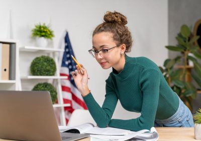 Jovem adulta buscando informações sobre a taxa do visto americano, para planejar sua viagem ao páis com o cuidado necessário.