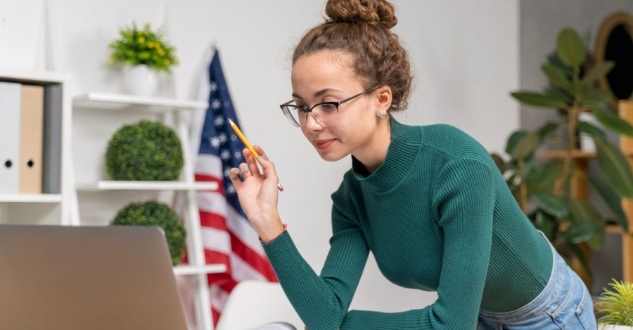 Jovem adulta buscando informações sobre a taxa do visto americano, para planejar sua viagem ao páis com o cuidado necessário.