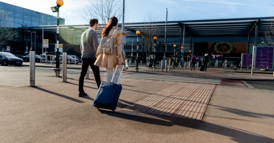 Imagem ilustrativa sobre o visto de trânsito nos EUA mostrando um casal de turistas passando por um aeroporto no país.