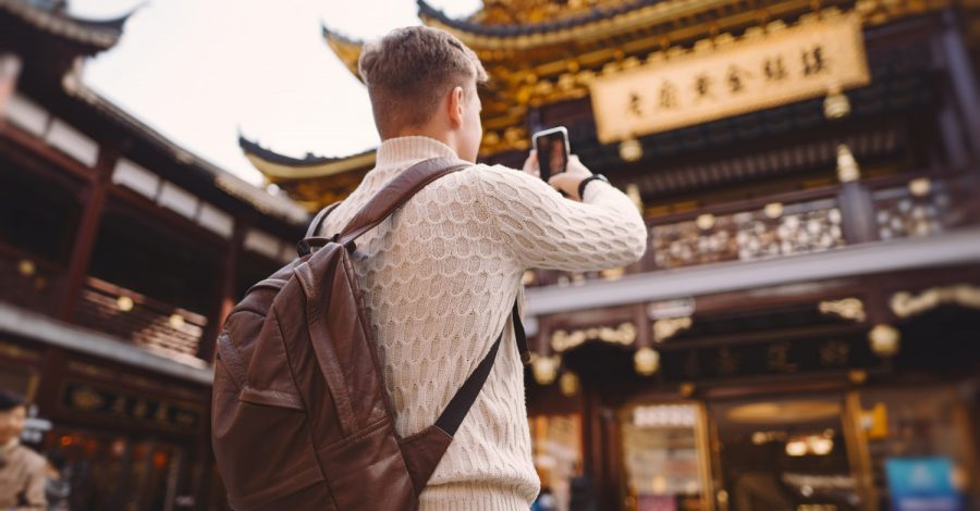 Imagem ilustrativa sobre visto chinês para brasileiros mostrando um jovem brasileiro fotografando pontos turísticos chineses após conseguir seu visto de turismo com o auxílio da Singular Mobilidade Internacional.