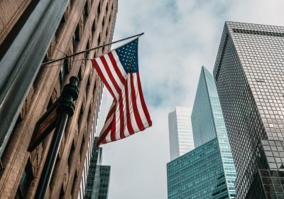 Imagem ilustrativa sobre os vistos americanos mostrando um prédio com a bandeira dos Estados Unidos hasteada.