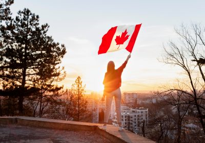 Mulher balançando uma bandeira canadense após conseguir seu visto de trabalho no Canadá.