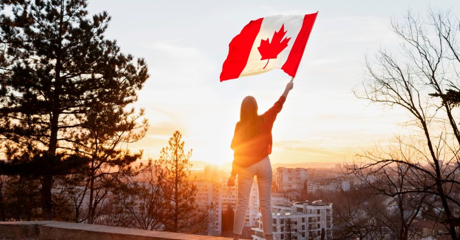 Mulher balançando uma bandeira canadense após conseguir seu visto de trabalho no Canadá.